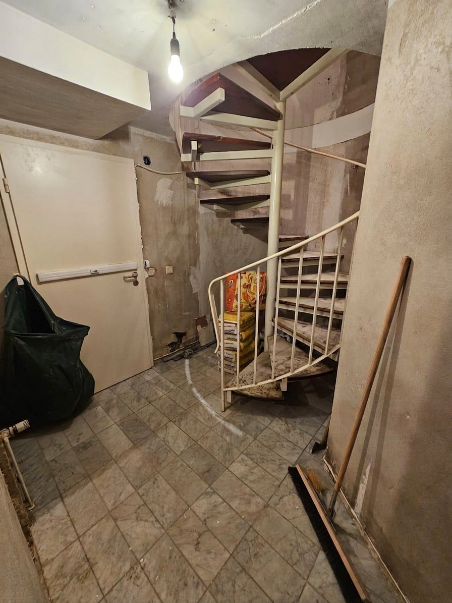 Vorher: der Bestand mit alter Wendeltreppe, schadhaftem Putz und abgenutztem Bodenbelag.
